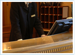 Hotel employee standing behind the front desk