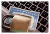 social security card sitting on top of computer keyboard with padlock on top of it