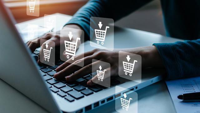 person using a laptop, shopping cart icons are superimposed on image