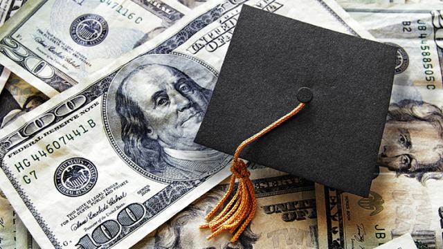 graduation cap on top of money